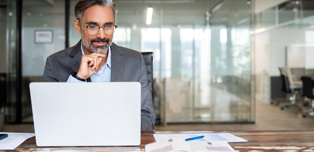Businessman focusing on his laptop while seated in an office.