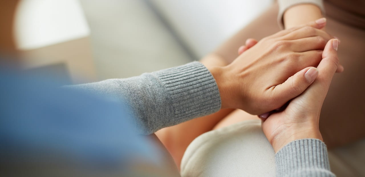 Close-up view of people holding hands.